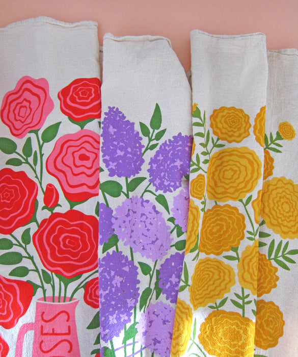 Rose, lilac, and marigold floral-themed tea towels laid side by side.