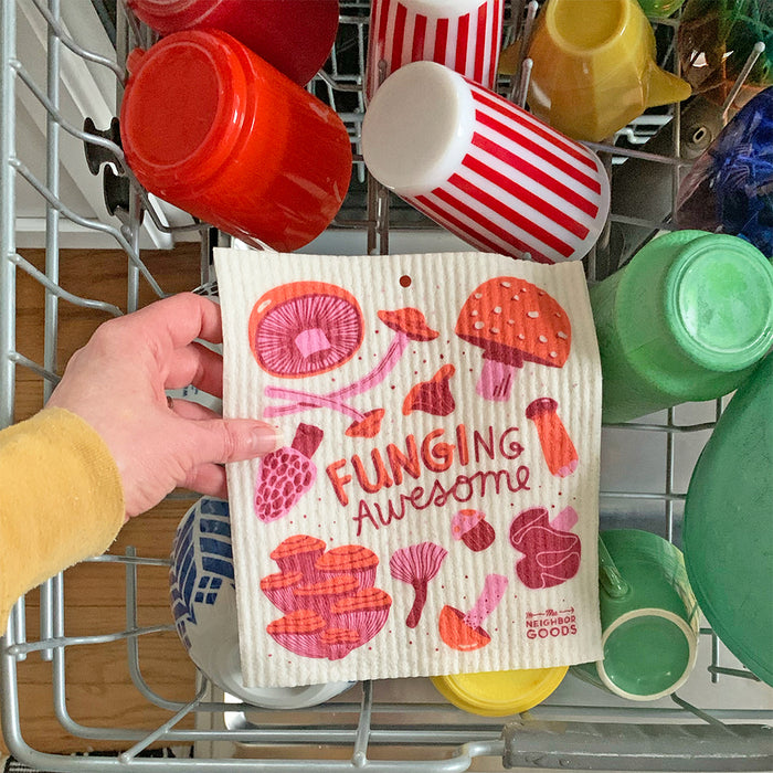 A woman places the mushroom sponge cloth on the top rack of the dishwasher.