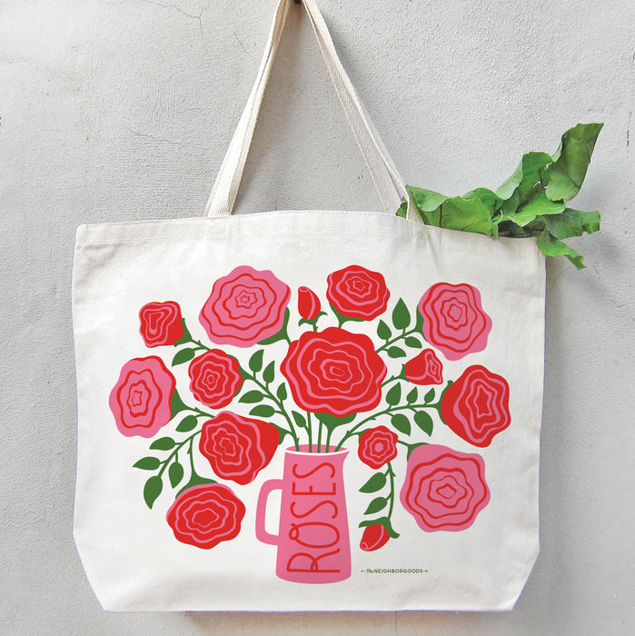 Roses tote bag filled with produce, hanging on a wall.