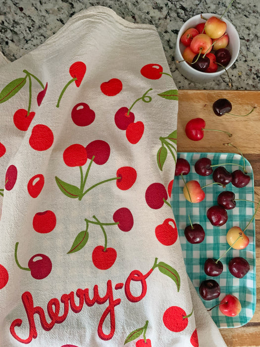 Cherry dish towel and cherries on cutting board