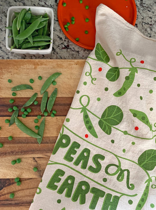 Peas dish towel photographed with peas on a cutting board