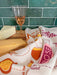 Cheese and wine dish towels photographed with cheese wedges and a glass of wine