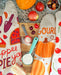 Pie, gourd, and cherry dish towels photographed on a counter with baking ingredients
