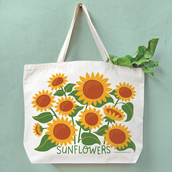 Sunflowers tote bag filled with green leafy produce, with the greens peeking out from the top.