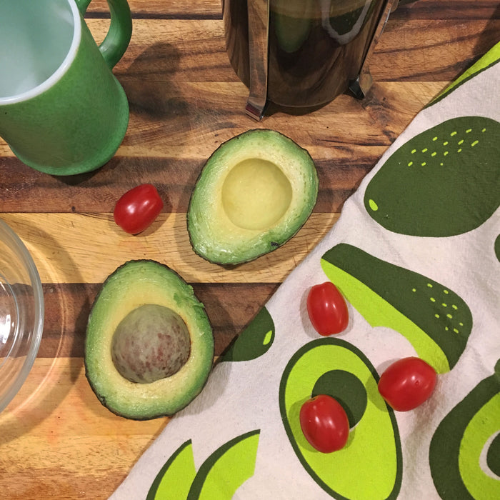 Sliced avocado and cherry tomatoes on a Avocado dish towel