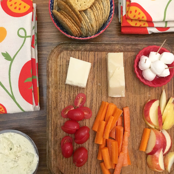 Folded tomato dish towels used as napkins on dinner table