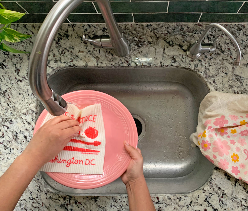 DC sponge cloth being used to clean dishes in a sink