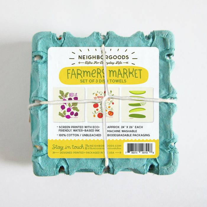 Bottom of farmers market dish towel set, featuring a sticker showing the designs of three towels packaged inside