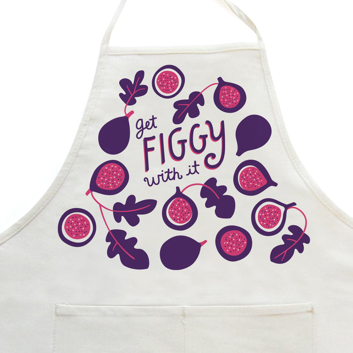 Close-up on white apron with figs design, featuring the phrase "Get figgy with it"