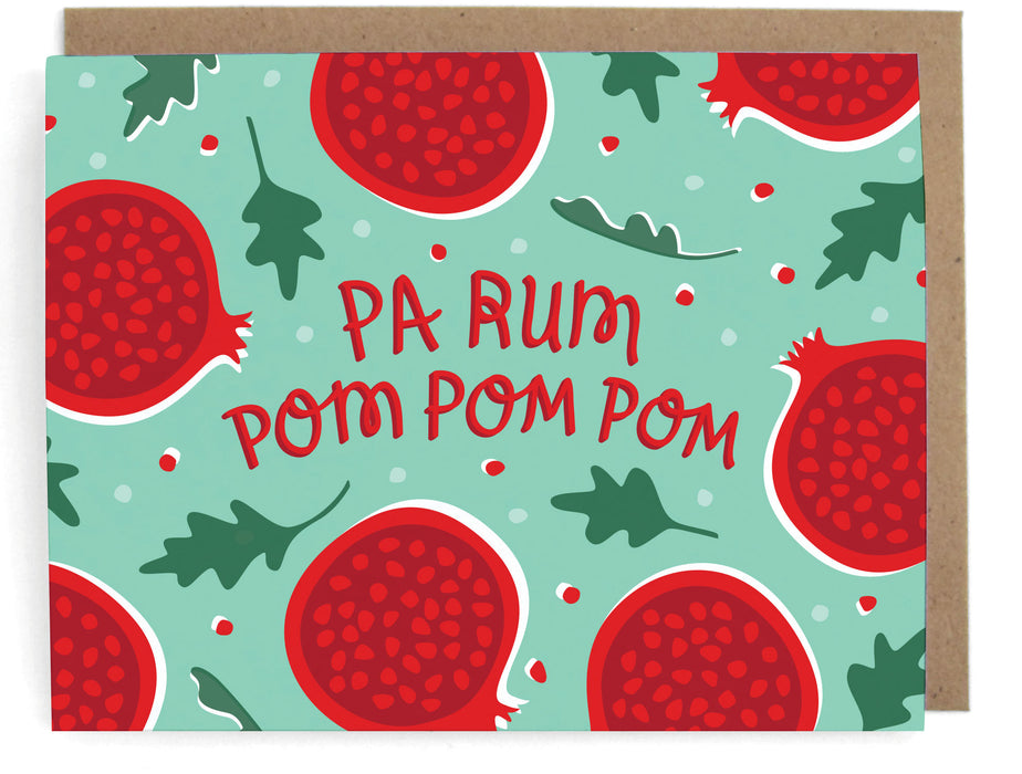 Teal card with pomegranate holiday design, featuring the phrase "Pa rum pom pom pom," with a brown envelope