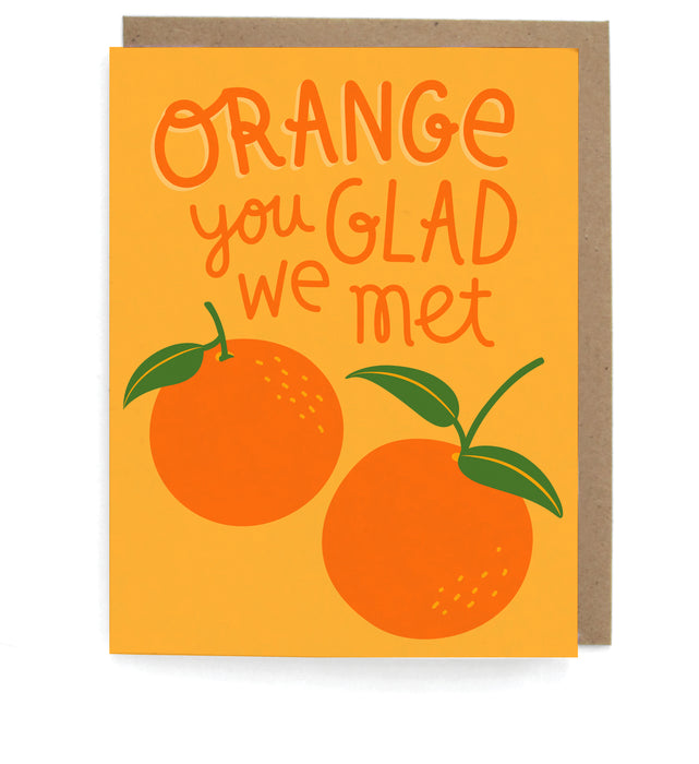 Orange card with oranges design, featuring the phrase "Orange you glad we met," with a brown envelope