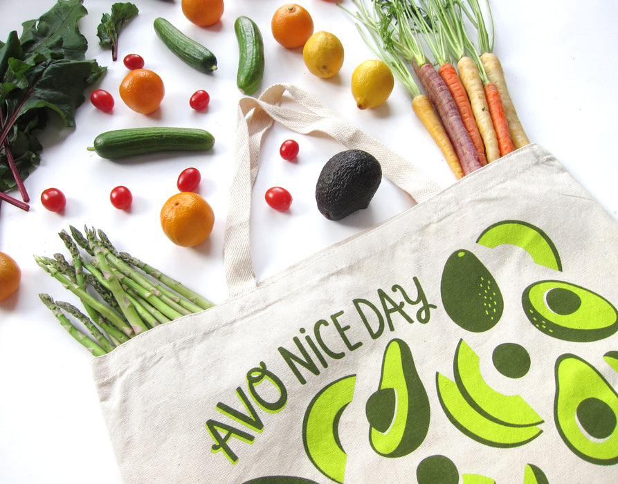Avocado tote bag photographed at an angle with an array of produce
