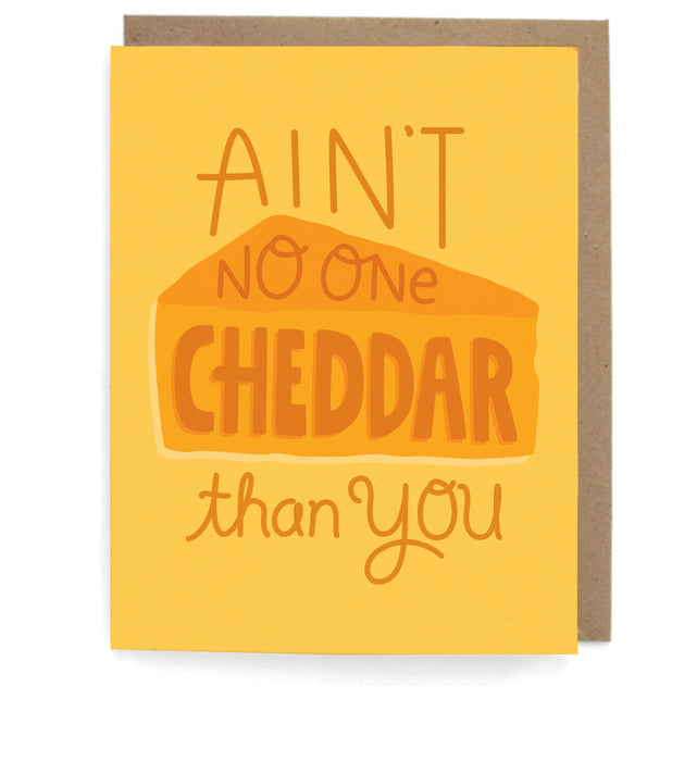 Yellow card that pictures a wedge of orange cheese, featuring the phrase "Ain't no one cheddar than you," with a brown envelope