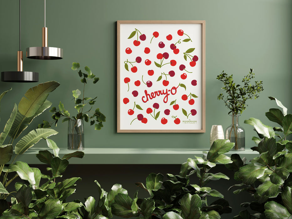 Cherries print framed amongst several houseplants