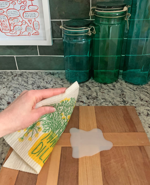Wettened dill sponge sponge cloth being used to clean up a spill
