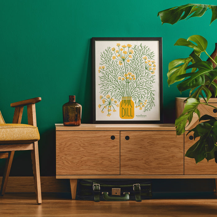Dill print in medium size framed on a stand next to a chair and plant