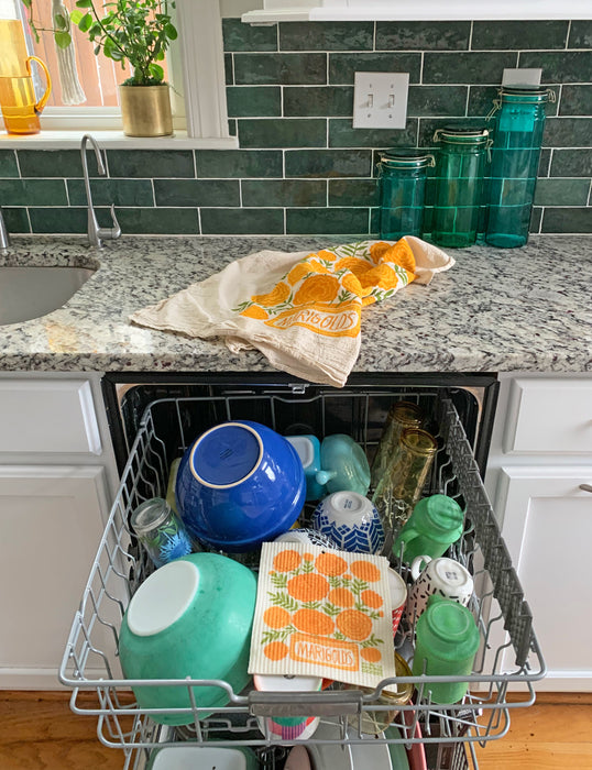 A marigolds sponge cloth is placed on the top rack of a dishwasher.