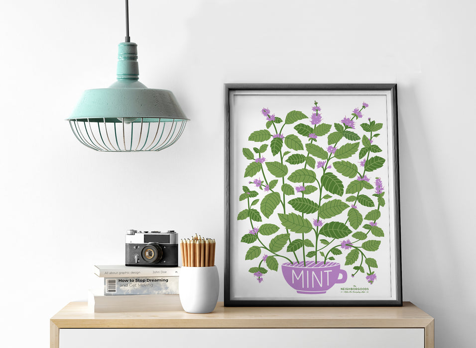 Mint print in medium size alongside light, camera, pencils, and books