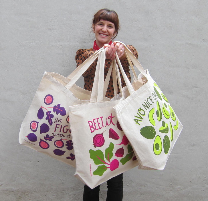 Neighborgoods founder, Jodi, holding the beets tote bag, along with the figgy and avocado tote bags