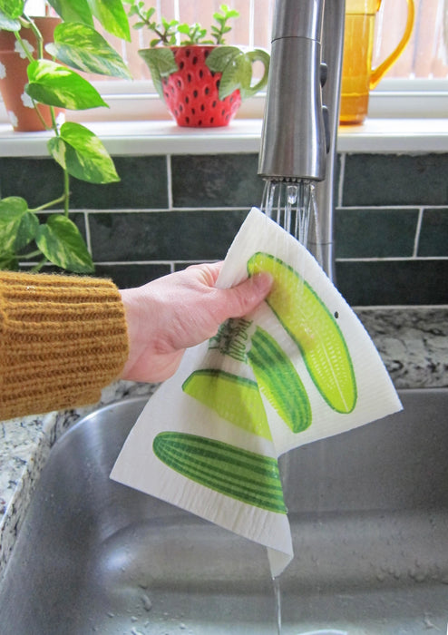 Pickles sponge cloth being put under running water in a sink