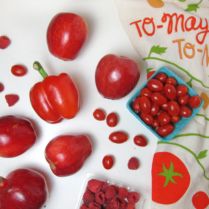 Red colored fruits and veggies pictured alongside tomato dish towel