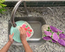 Roses sponge cloth being put under running water in a sink