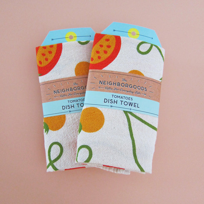 Front view of two tomato dish towels individually packaged in branded belly band sleeves