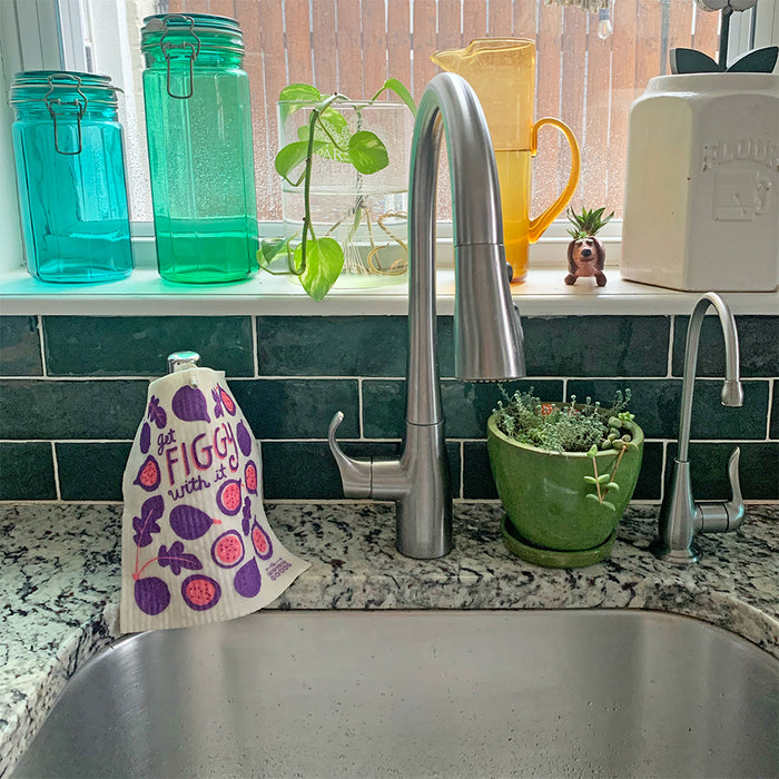 A fig sponge cloth hangs to dry on hand soap dispenser.