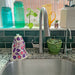 A fig sponge cloth hangs to dry on hand soap dispenser.