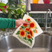 A wet sunflower sponge cloth under sink faucet.