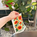 A woman hanging a wet sunflower sponge cloth to dry.