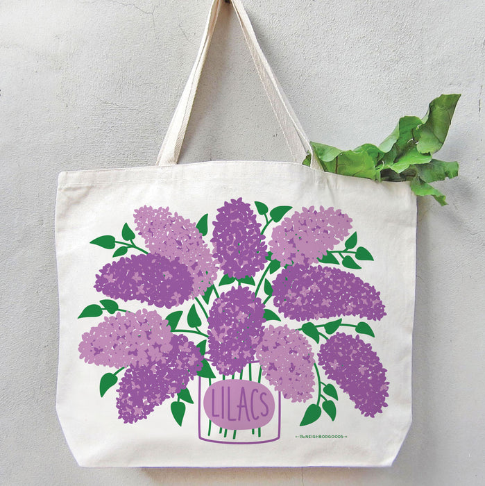 Lilac tote bag filled with green leafy produce, with the greens peeking out from the top.