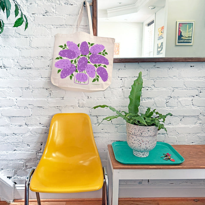 A Lilac tote bag hangs from mirror hook.