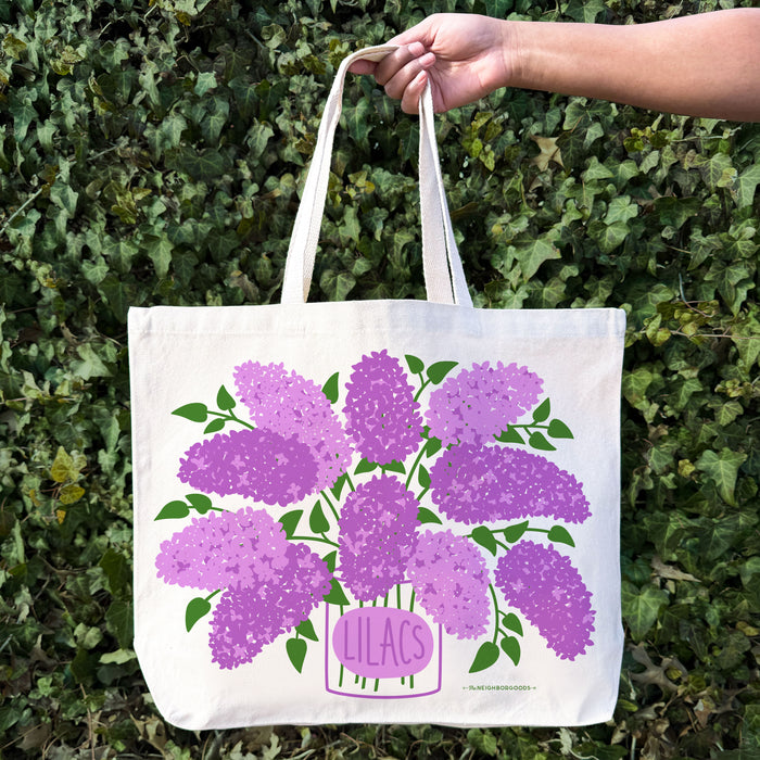A woman holds the Lilac tote bag.