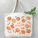 Peach tote bag filled with green leafy produce, with the greens peeking out from the top.