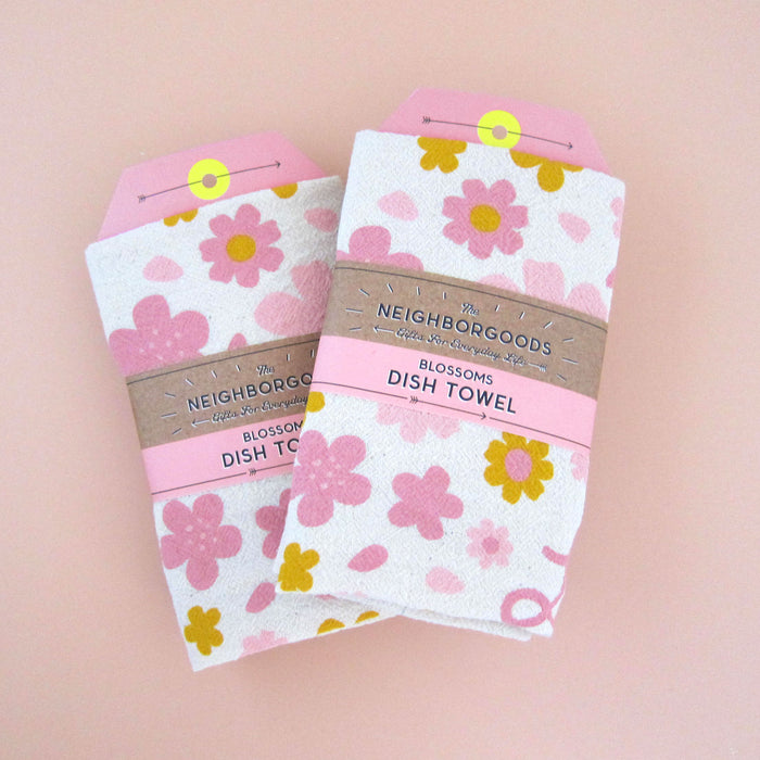 Two Cherry Blossom towel souvenirs. Both towels are packaged in The Neighborgoods branded belly band.