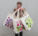Neighborgoods founder, Jodi, holding the avocado tote bag, along with the figgy and beet tote bags